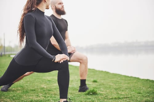 A couple stretching outdoors demonstrating RV healthy living